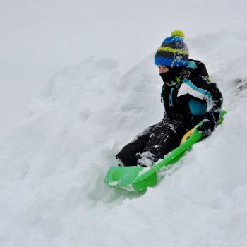 un enfant fait de la luge dans les Vosges dans une station de ski familiale